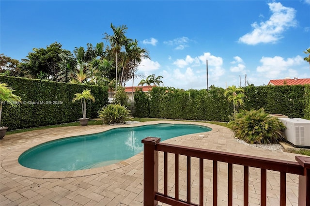 view of pool with cooling unit and a patio