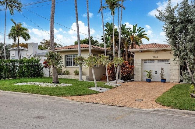 mediterranean / spanish house with a garage and a front lawn