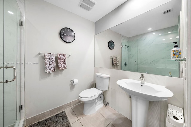 bathroom with toilet, tile patterned flooring, and walk in shower