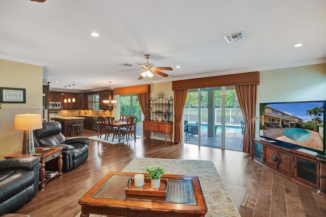 living room featuring plenty of natural light, hardwood / wood-style floors, and crown molding