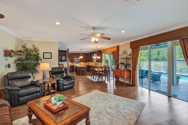 living room featuring ceiling fan, ornamental molding, and hardwood / wood-style flooring