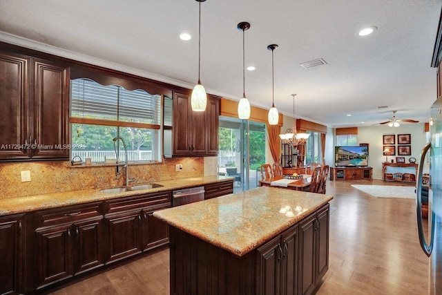 kitchen featuring pendant lighting, appliances with stainless steel finishes, a center island, sink, and dark brown cabinets