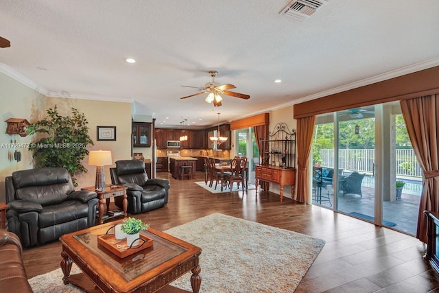 living room with ceiling fan, a textured ceiling, hardwood / wood-style flooring, and crown molding