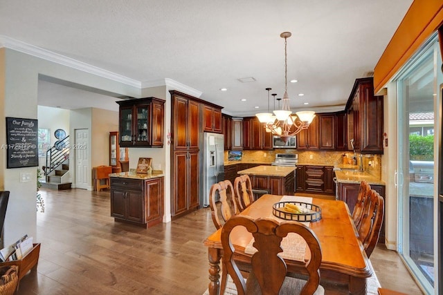 dining room with hardwood / wood-style flooring, crown molding, and a notable chandelier