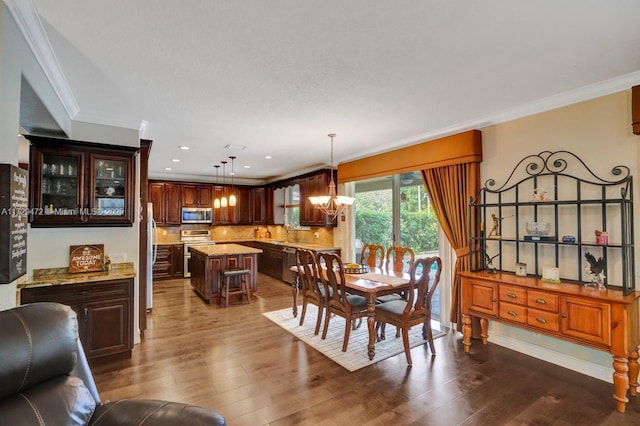 dining area with dark hardwood / wood-style floors, crown molding, and a chandelier