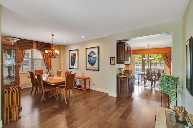 dining area featuring dark wood-type flooring and a chandelier