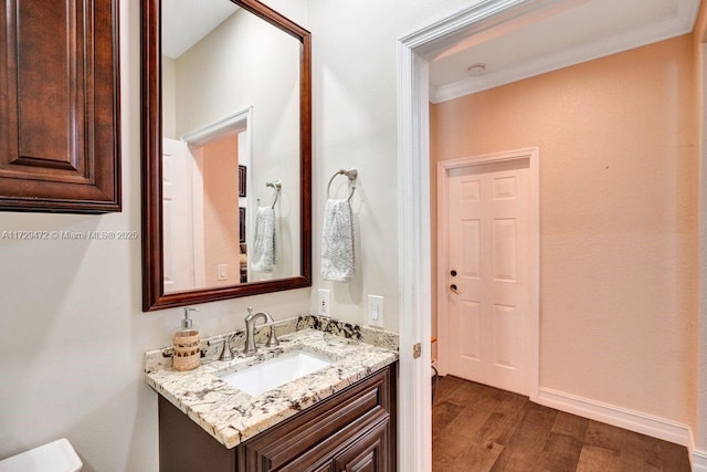 bathroom featuring vanity, crown molding, and hardwood / wood-style floors