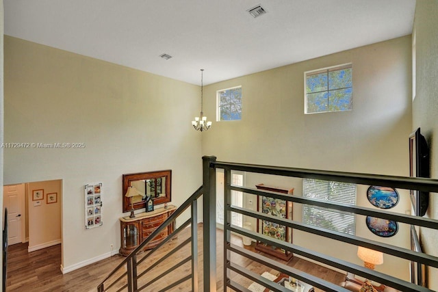 stairway featuring hardwood / wood-style floors and a chandelier