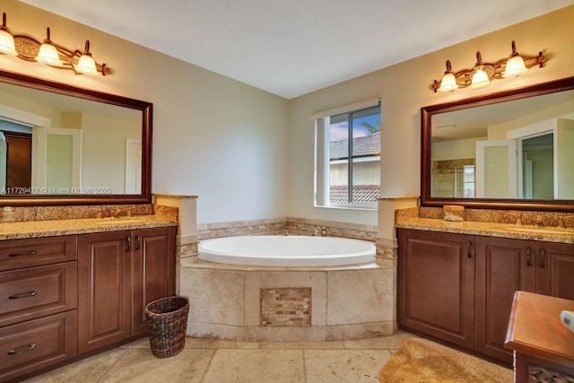 bathroom featuring tiled tub and vanity