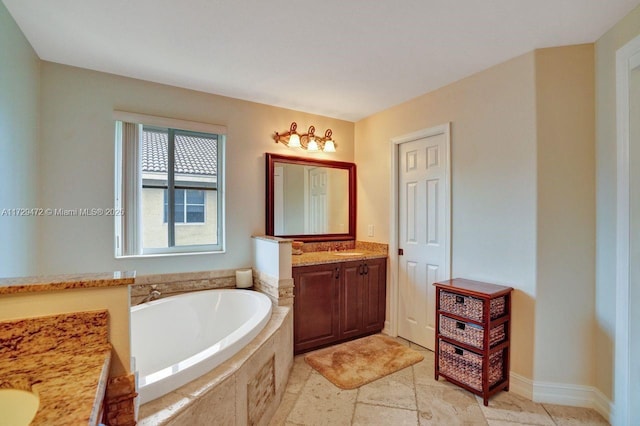 bathroom featuring a relaxing tiled tub and vanity