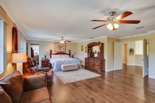 bedroom featuring a textured ceiling, ceiling fan, ornamental molding, and dark hardwood / wood-style floors