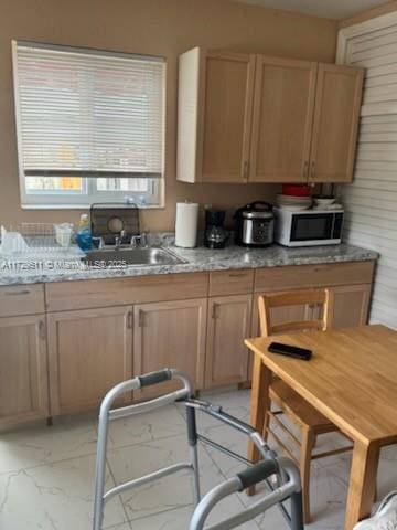 kitchen with sink, light brown cabinets, and light stone counters