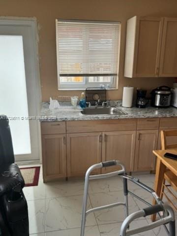 kitchen featuring sink and light stone countertops