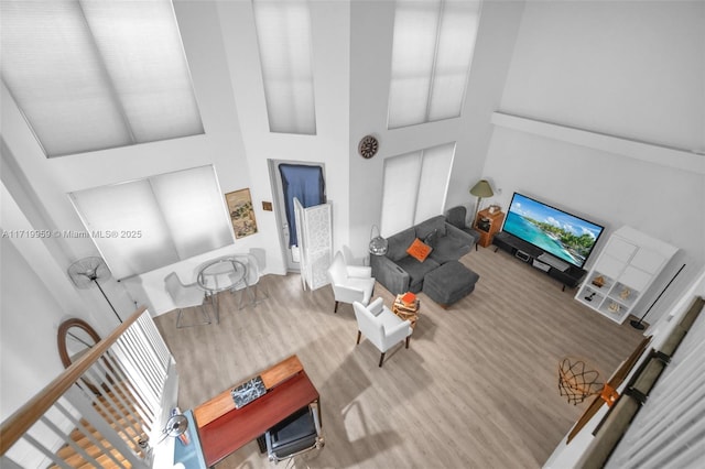 living room featuring hardwood / wood-style flooring and a towering ceiling