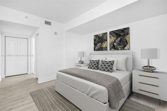 bedroom with a closet and light hardwood / wood-style floors