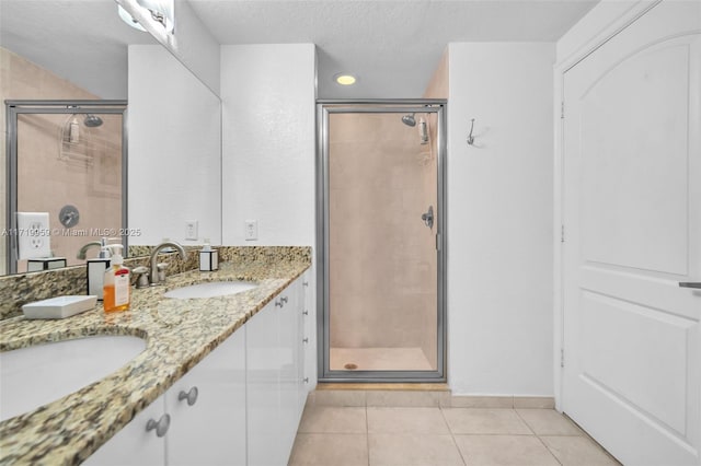 bathroom featuring walk in shower, vanity, tile patterned floors, and a textured ceiling