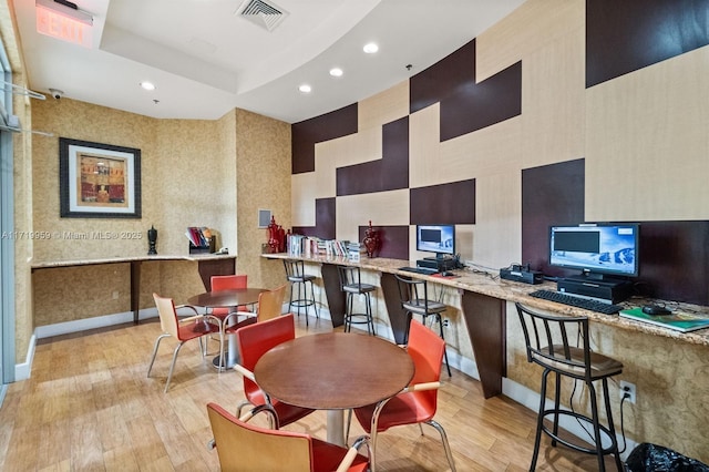 dining room featuring a raised ceiling and light wood-type flooring