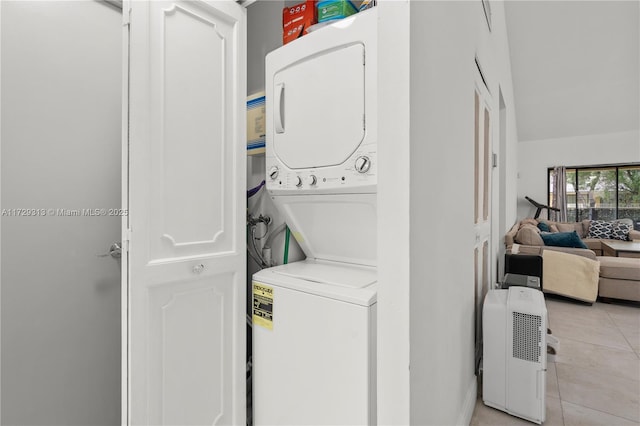 laundry area featuring light tile patterned floors and stacked washer / drying machine