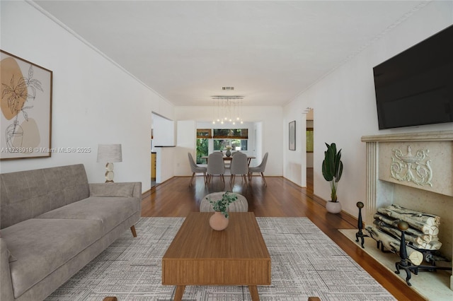 living room featuring ornamental molding, hardwood / wood-style floors, and a notable chandelier