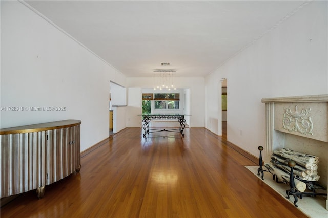 corridor with a notable chandelier, hardwood / wood-style flooring, and ornamental molding