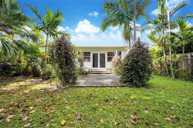 back of property with a yard, a patio, and french doors