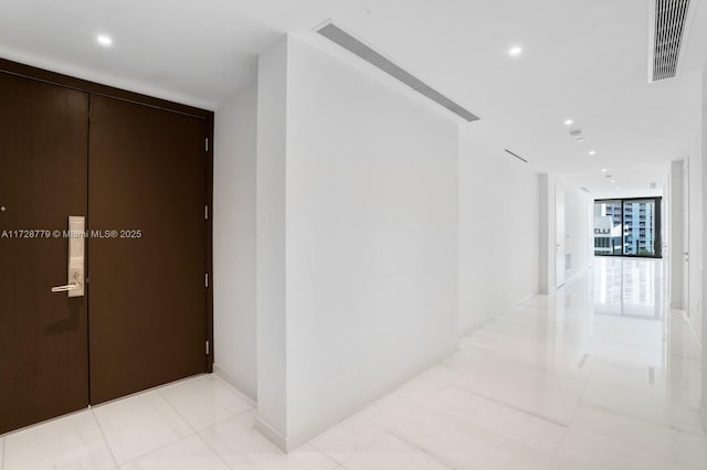 hallway with light tile patterned flooring and expansive windows