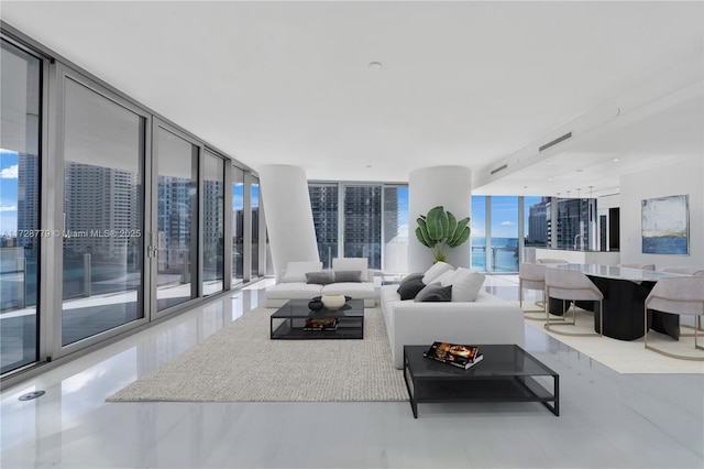 living room featuring a healthy amount of sunlight, visible vents, and a wall of windows