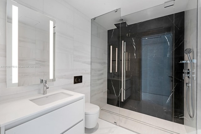 bathroom with toilet, a tile shower, tile walls, and vanity