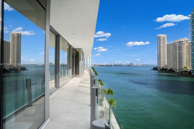 balcony with a water view and a view of city