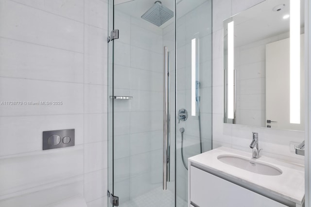 bathroom with a shower with door and vanity