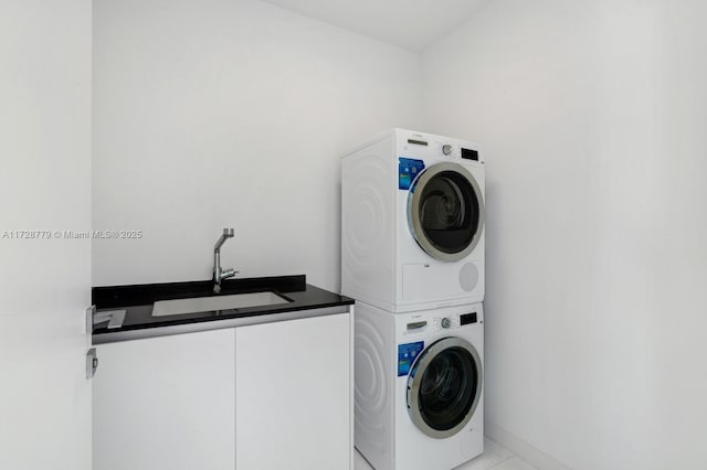 laundry room featuring stacked washer / dryer, sink, and light tile patterned floors