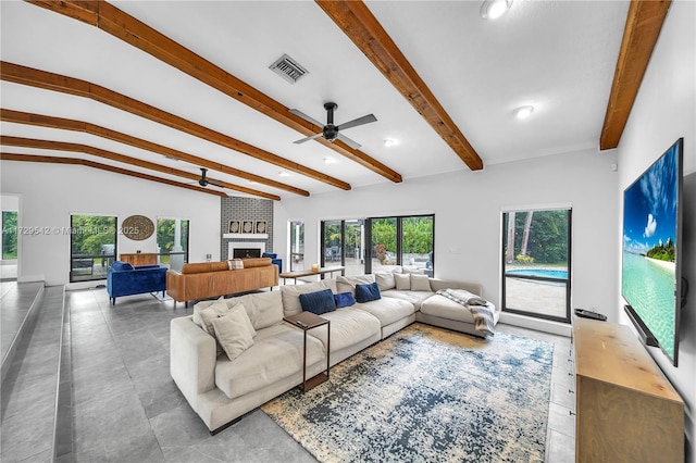 living room featuring ceiling fan, lofted ceiling with beams, and a fireplace