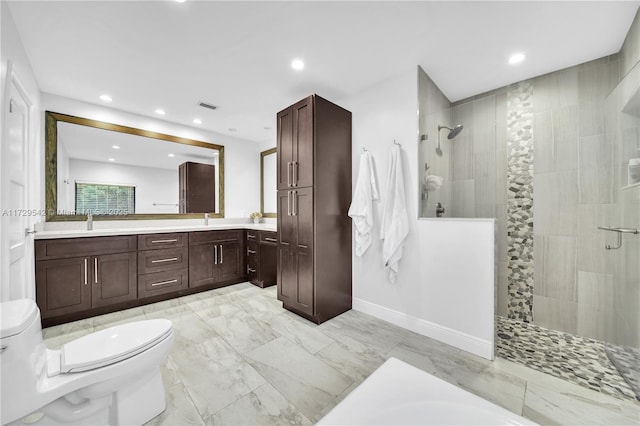 bathroom with tiled shower, toilet, and vanity