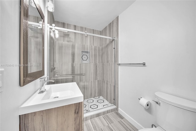 bathroom with toilet, vanity, and an enclosed shower