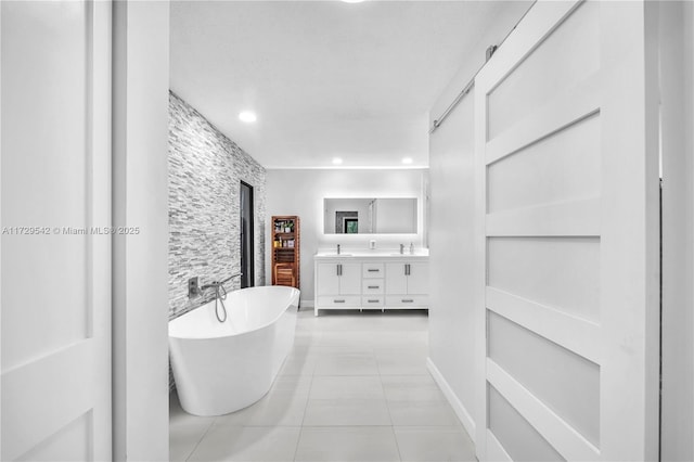 bathroom featuring a tub to relax in, vanity, and tile patterned flooring