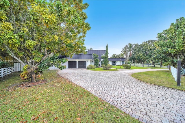 single story home featuring a garage and a front yard