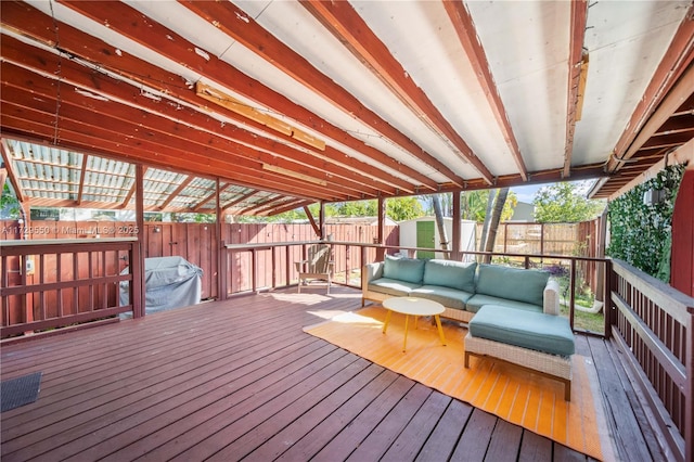 wooden deck featuring a fenced backyard, an outdoor structure, an outdoor hangout area, and a shed