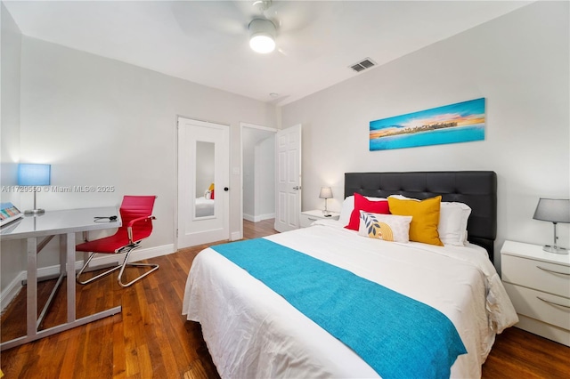 bedroom featuring baseboards, visible vents, dark wood finished floors, and a ceiling fan