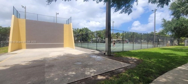 view of sport court with a yard and fence