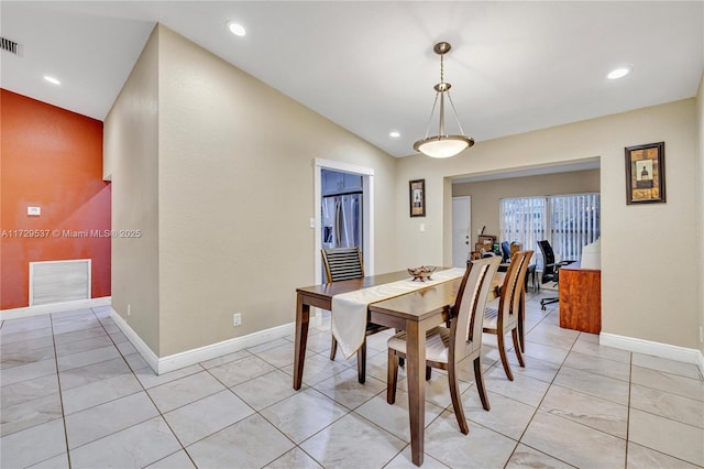 dining area featuring light tile patterned flooring and vaulted ceiling