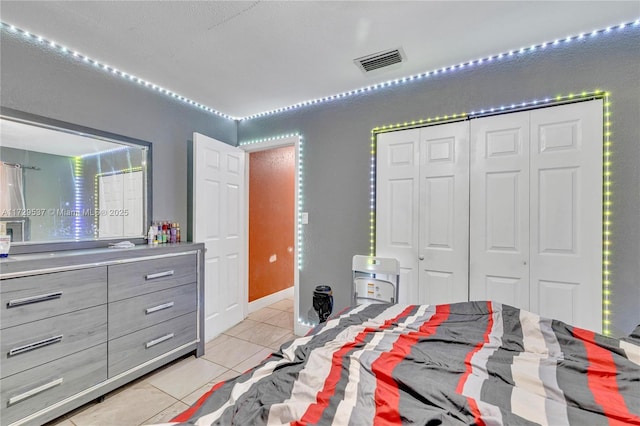 bedroom with a closet and light tile patterned floors