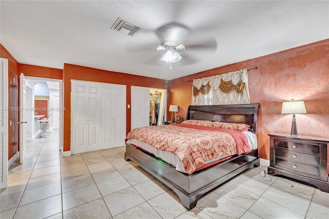 tiled bedroom featuring ceiling fan