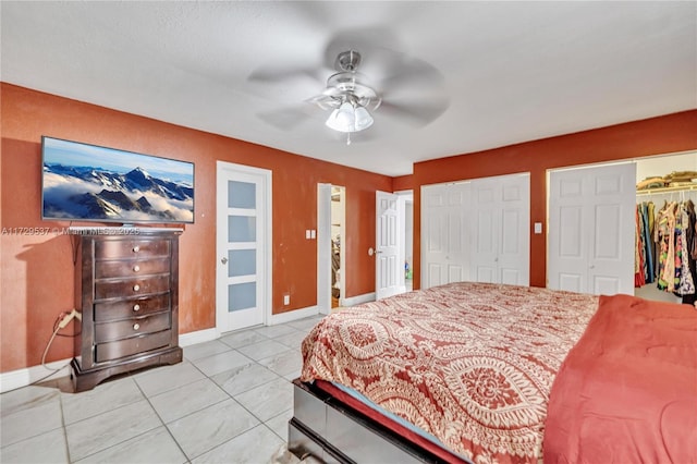 bedroom with ceiling fan, multiple closets, and light tile patterned flooring