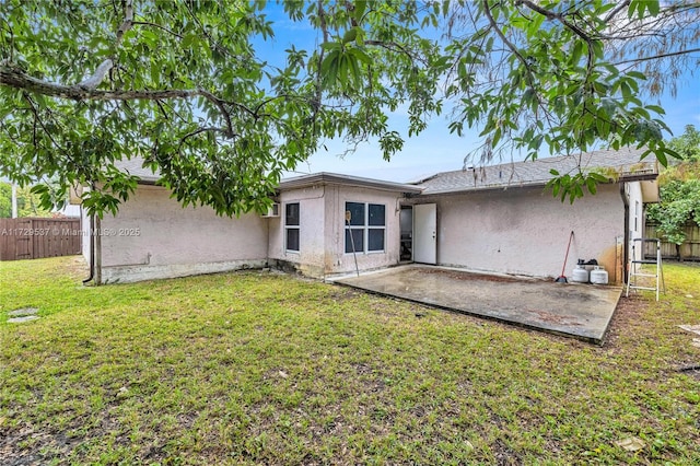 back of property with a patio and a yard