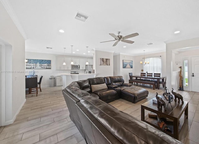 living room featuring ornamental molding and ceiling fan with notable chandelier