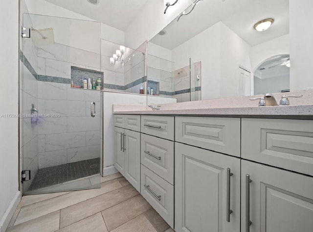 bathroom with a shower with door and vanity