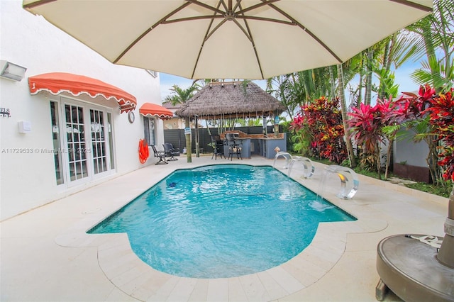 view of swimming pool featuring a patio area, an outdoor bar, and pool water feature