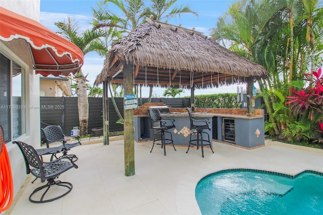 view of swimming pool with a bar, a gazebo, and a patio