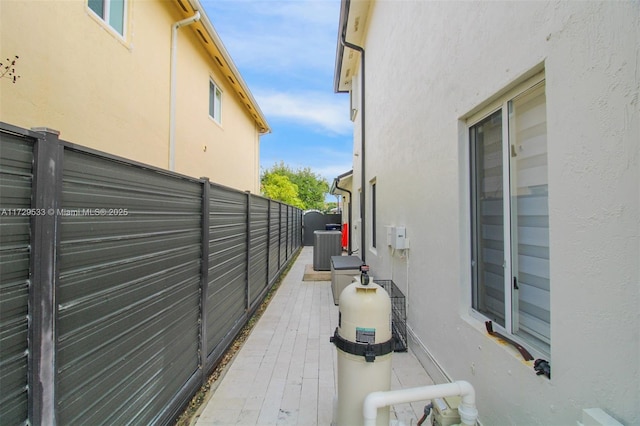 view of property exterior with central AC unit and a patio