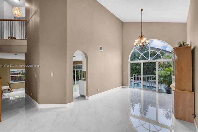 interior space featuring a chandelier and a high ceiling